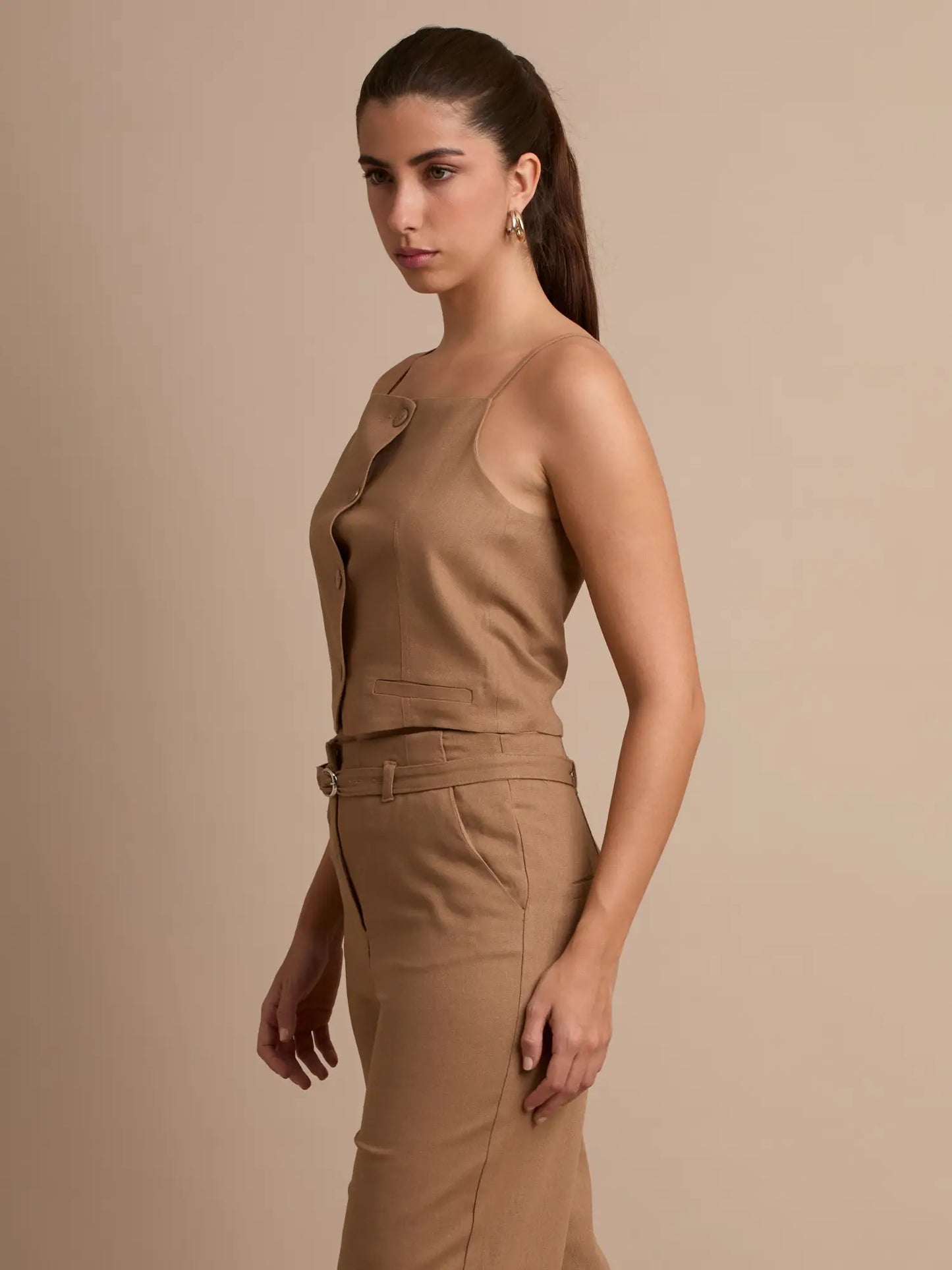 Con un diseño moderno de líneas rectas, este top se adapta a cualquier ocasión. Sus botones centrales y su tono neutro aportan sofisticación y atemporalidad.