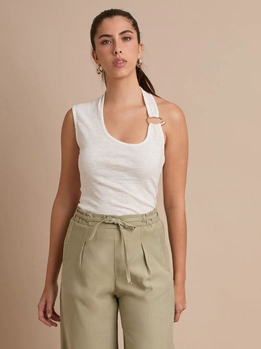Este top ajustado en tono blanco destaca por su tirante halter adornado con dos aros dorados que acentúan el escote. Una prenda cómoda, moderna y perfecta para cualquier ocasión.