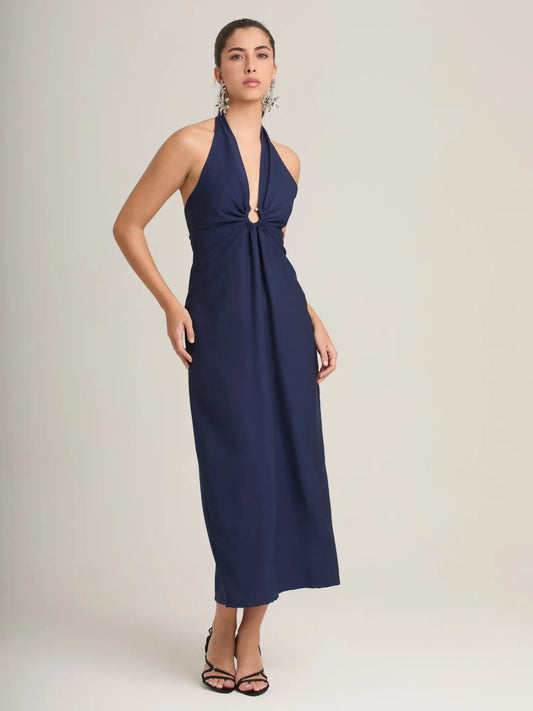 El vestido azul marino halter destaca por su elegancia atemporal, con una argolla central que estiliza y una falda midi que aporta sofisticación. Perfecto para eventos de noche y cenas especiales.