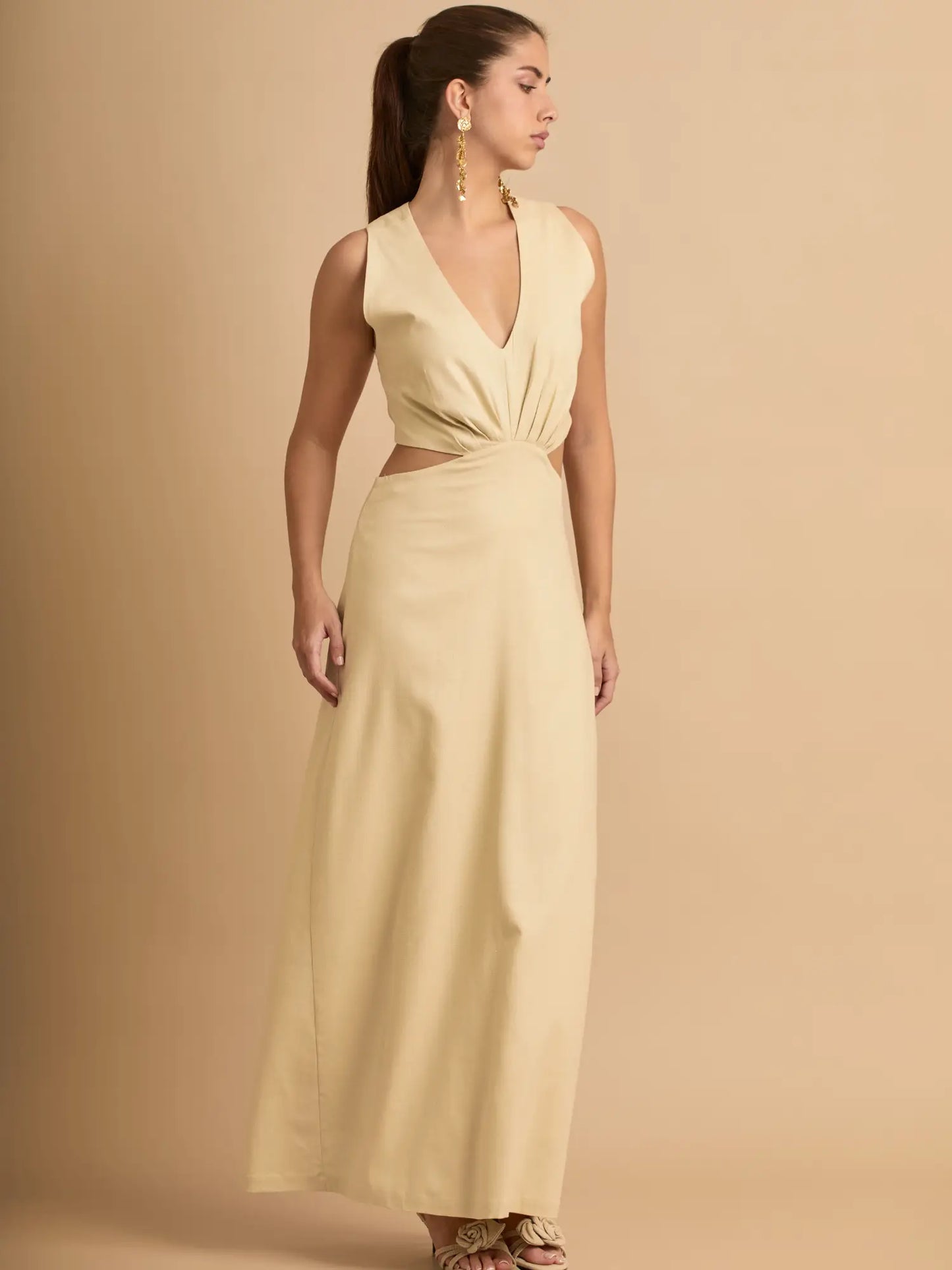 El vestido beige elegante ofrece una silueta alargada con aberturas laterales que realzan la cintura. Su diseño minimalista lo convierte en una opción atemporal y sofisticada.