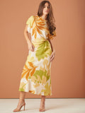Vestido largo con estampado tropical en tonos cálidos, tiene mangas cortas, un diseño de nudo en la cintura que resalta la figura, y está confeccionado en una tela ligera, ideal para climas cálidos o eventos casuales.

Detalles: 
Color: Blanco estampado
Material: 90% Rayon y 10% Nylon