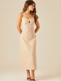 Este vestido tiene un diseño elegante y minimalista. De largo midi y tirantes delgados, destaca por su escote corazón con un pequeño corte central que aporta un toque moderno y sutilmente sensual. La tela estructurada y ligera lo hace ideal para climas cálidos, y combinado con sandalias de tacón y joyería dorada, logra un look sofisticado y femenino.