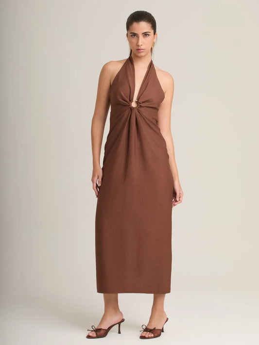El vestido marrón halter combina un diseño sofisticado con una argolla central que realza la silueta. Su falda midi recta aporta elegancia y un estilo moderno perfecto para eventos o cenas especiales.