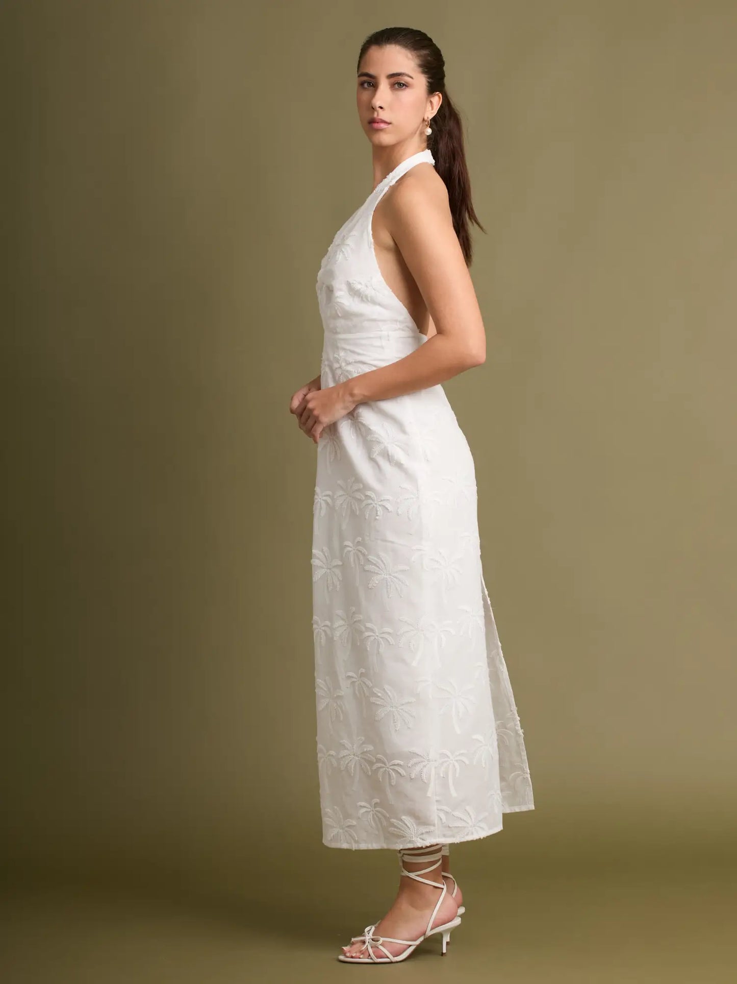 Un vestido fresco y sofisticado confeccionado con bordado en relieve de inspiración tropical. El escote halter y el detalle frontal añaden un toque refinado y moder