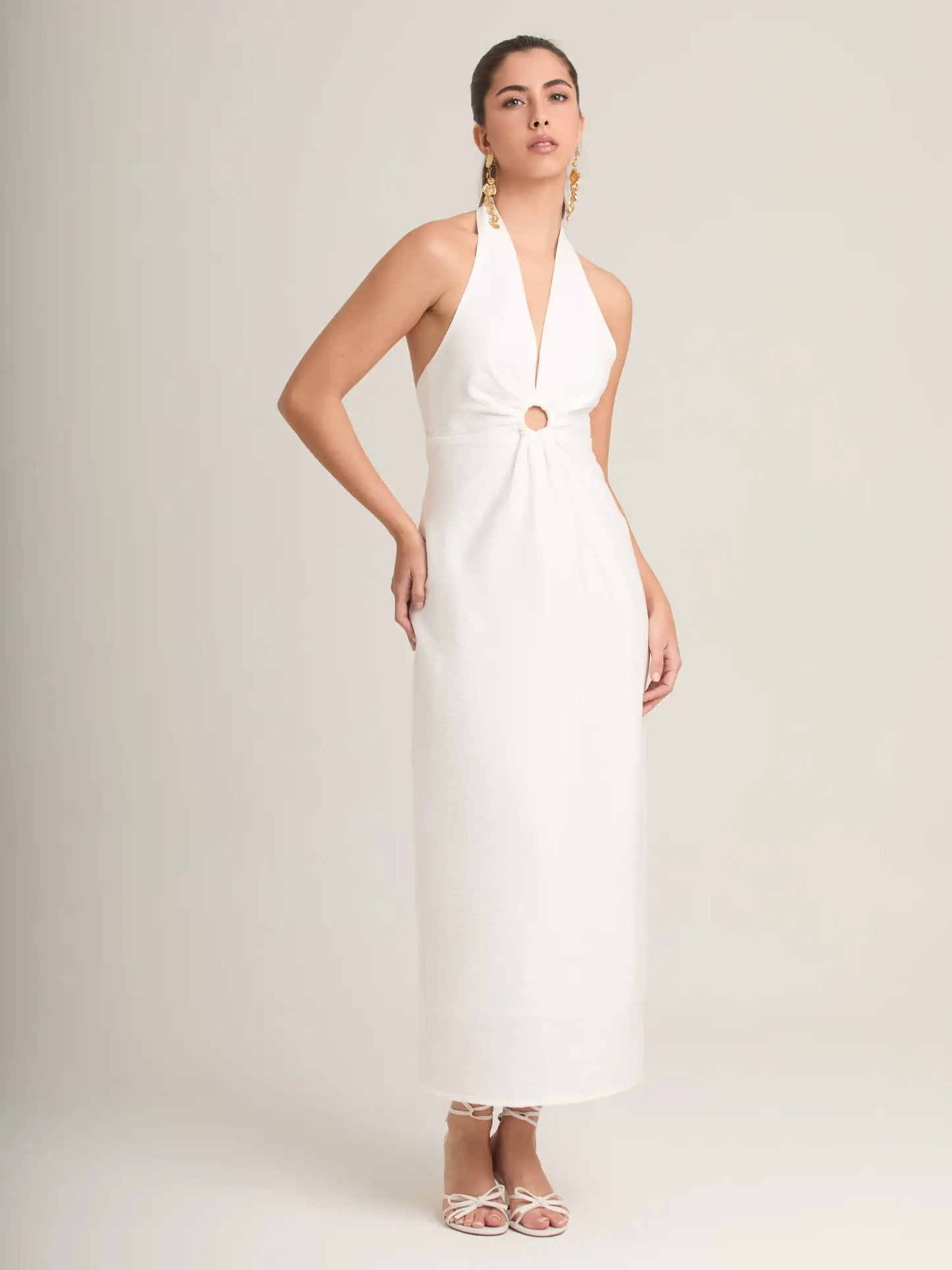 El Palmeral Blanco es un vestido midi de estilo sofisticado que combina un escote halter profundo con un detalle central de aro que realza la figura. Su silueta alargada y minimalista aporta un look moderno y elegante, ideal para eventos de verano, fiestas al aire libre y ocasiones especiales. Su diseño limpio, fresco y femenino garantiza un estilo impecable en cualquier momento del día.
