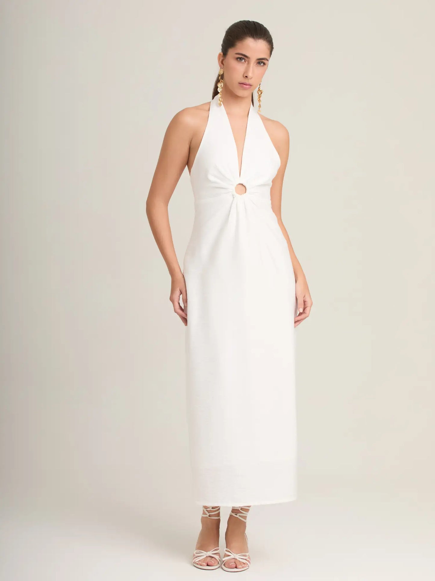 El Palmeral Blanco es un vestido largo con escote halter, corte recto y aro central que crea un efecto cut-out favorecedor. Ideal para verano, fiestas, vacaciones o looks casual-chic. Su diseño limpio y femenino lo convierte en una pieza versátil para cualquier ocasión.