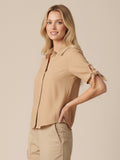 Blusa camisera de manga corta con lazo en los puños. Lleva cuello clásico y botonadura al frente, con silueta recta y dobladillo curvo a la cadera que estiliza. Versátil y pulida: perfecta para elevar jeans, faldas o pantalón sastre

Detalles:

Color: sand