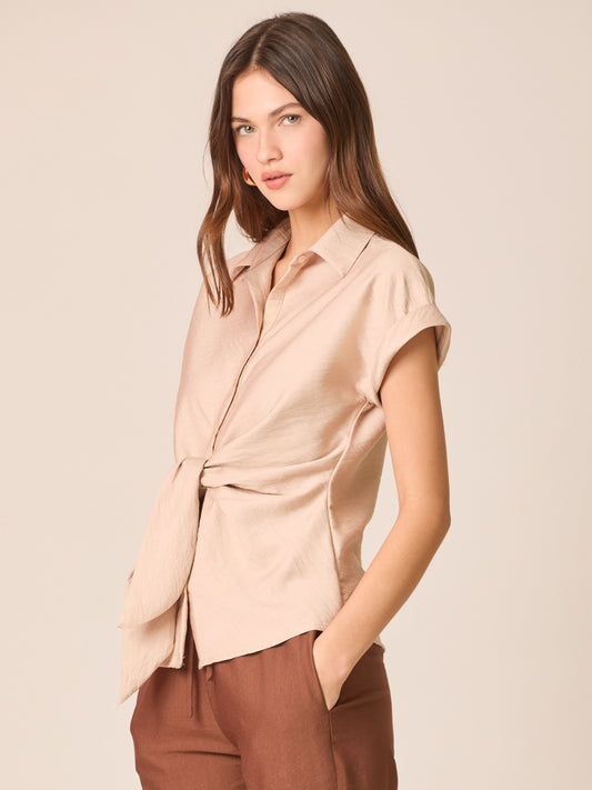 Blusa camisera de manga corta con cuello clásico y tapeta de botones. Destaca el nudo frontal que define la cintura, con puños vueltos y dobladillo curvo con pequeñas aberturas laterales. Caída ligera y fit relajado que estiliza y funciona del día a la noche

Detalles:

Color: Sand

Material: 87% Rayón 13% Poliamida.