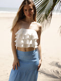 Diseño strapless con silueta ajustada al busto. Presenta capas de volantes superpuestos que aportan volumen y movimiento, creando un estilo femenino y llamativo. Ideal para looks frescos y veraniegos

Detalles:

Color: Blanco

Material: 90% Rayon 10% Poliester