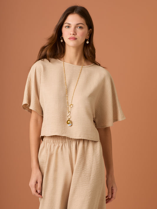 Sencilla y sofisticada, esta blusa de corte recto y fit suelto ofrece comodidad con un acabado limpio. Su diseño de manga corta y cuello cerrado la convierte en una prenda versátil, ideal para looks casuales o combinaciones minimalistas con un aire refinado. Perfecta para el día a día con estilo relajado y moderno.