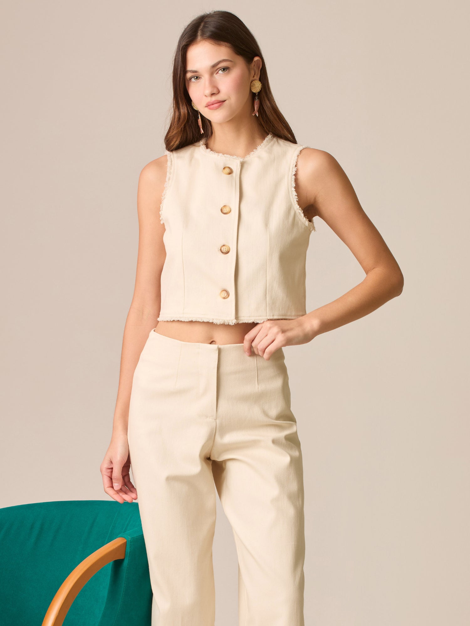 Blusa cropped sin mangas, escote redondo y botonadura frontal; bordes deshilachados y silueta entallada que realza la cintura—ideal para coordinar con tiro alto.

Detalles:

Color: Sand

Material: 98% Algodón 2% Elastomero

Cuidado: Lavar a mano con jabón suave, por separado.No dejar en remojo. Planchar a temperatura alta.