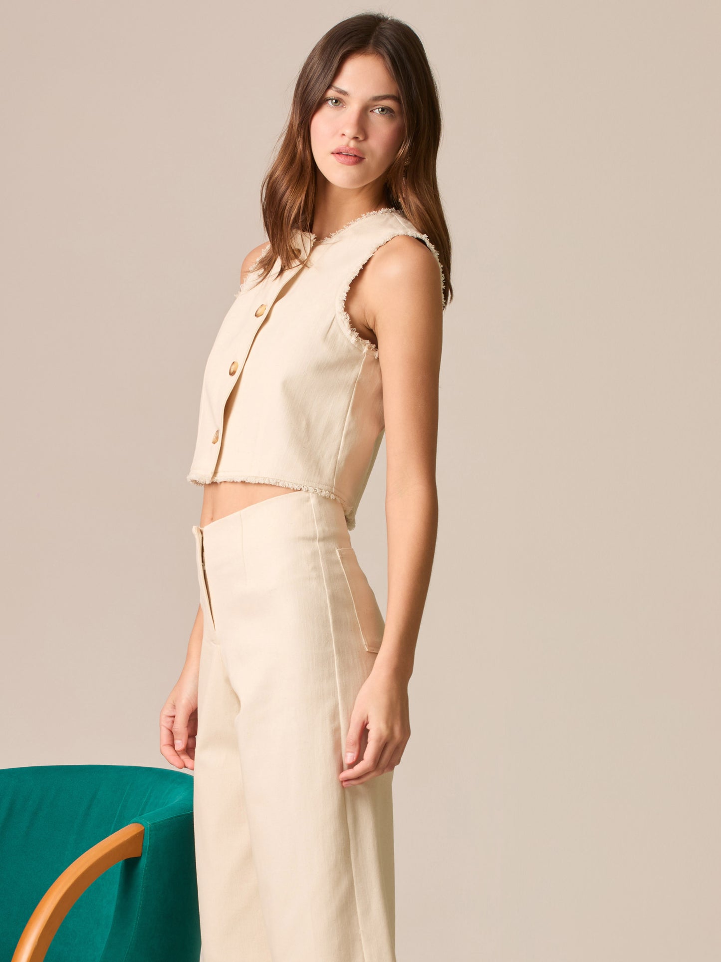 Blusa cropped sin mangas, escote redondo y botonadura frontal; bordes deshilachados y silueta entallada que realza la cintura—ideal para coordinar con tiro alto.

Detalles:

Color: Sand

Material: 98% Algodón 2% Elastomero

Cuidado: Lavar a mano con jabón suave, por separado.No dejar en remojo. Planchar a temperatura alta.