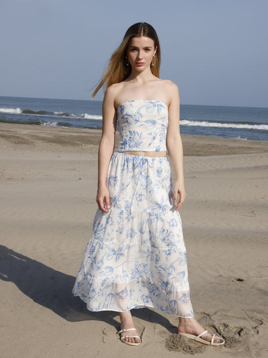 Esta falda es de corte largo, tipo maxi, confeccionada en una tela ligera ideal para climas cálidos. Presenta un estampado floral en tonos marrones sobre fondo blanco, lo que le da un estilo fresco y veraniego. Tiene un diseño de cintura alta con pretina plana que estiliza la figura y caída fluida con ligero vuelo, aportando movimiento al caminar. Es una prenda cómoda y elegante, perfecta para looks de playa o escapadas tropicales.

Detalles:

Color: Blanco

Material: 100% Lyocel