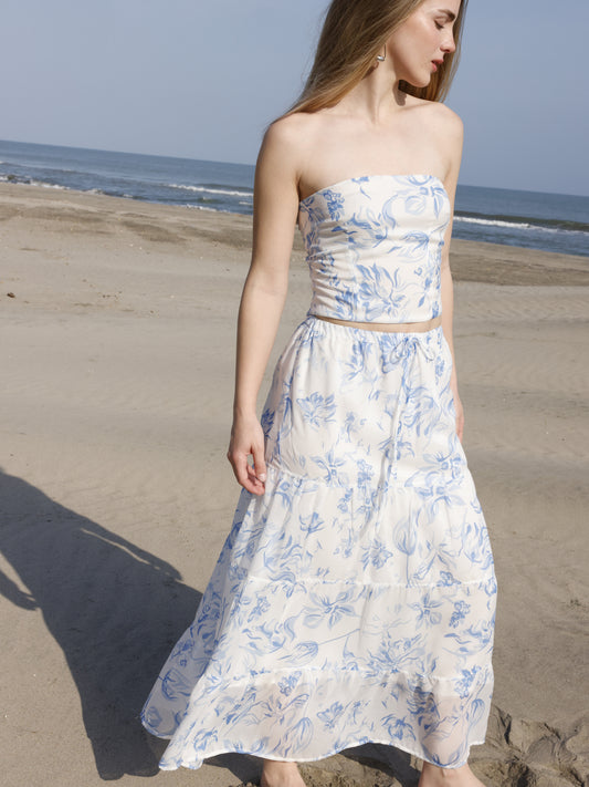 Esta falda es de corte largo, tipo maxi, confeccionada en una tela ligera ideal para climas cálidos. Presenta un estampado floral en tonos marrones sobre fondo blanco, lo que le da un estilo fresco y veraniego. Tiene un diseño de cintura alta con pretina plana que estiliza la figura y caída fluida con ligero vuelo, aportando movimiento al caminar. Es una prenda cómoda y elegante, perfecta para looks de playa o escapadas tropicales.

Detalles:

Color: Blanco

Material: 100% Lyocel