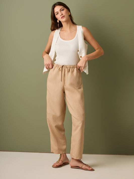 Pantalón de tiro medio con cintura elástica y cordón ajustable. Silueta relajada que cae con volumen en la cadera y se afina al tobillo, con bolsillos laterales y cortes decorativos en la pierna. Largo al tobillo con pequeña abertura en el bajo: la base moderna y versátil para elevar looks de día o de noche.

Detalles:

Color: Sand

Material: 77% Tencel 23% Lino 100% Rayón