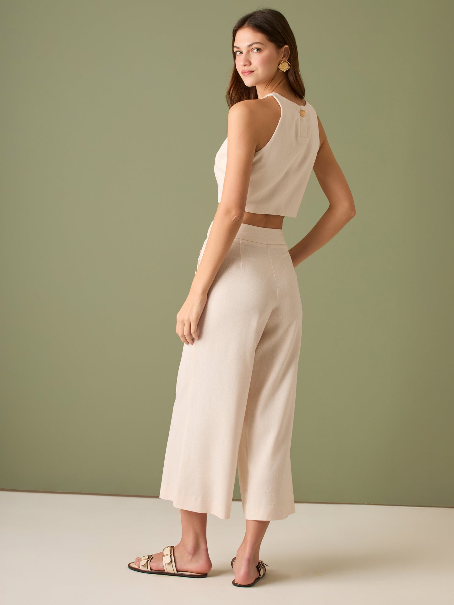 Pantalón culotte de tiro alto y pierna ancha; largo cropped que alarga la silueta, cintura entallada y botones laterales estilo marinero—versátil y elegante para looks casual-chic

Detalles:

Color: Ivory

Material: 100% lino. Forro 100% Rayón
