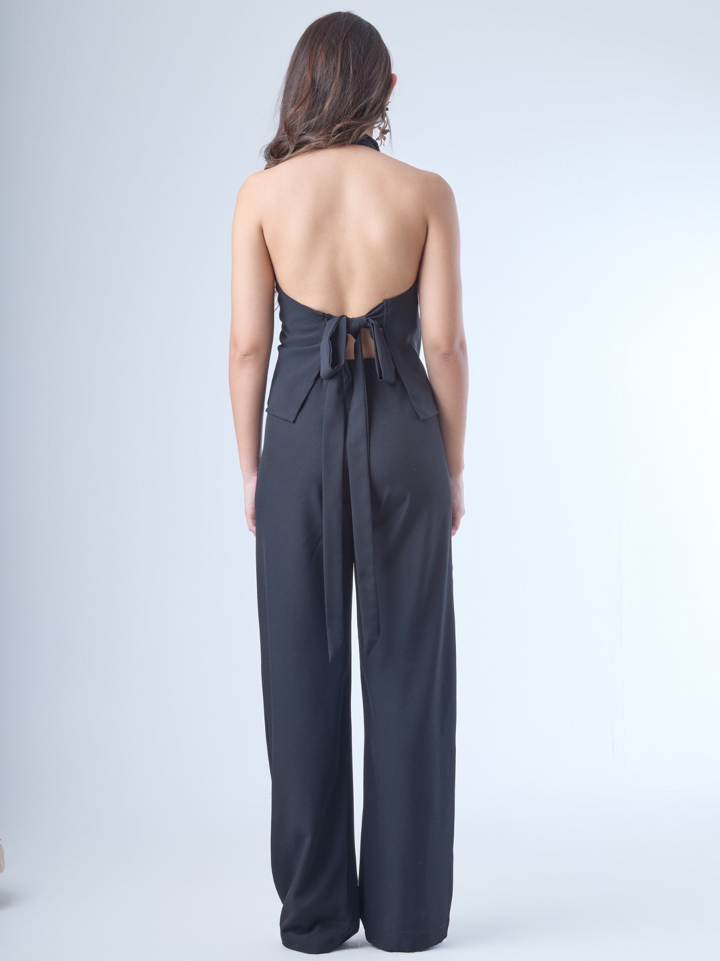 Pantalón de corte recto y tiro alto, con pretina ancha y cinturón del mismo tejido que se anuda al frente. Tiene silueta fluida y caída suave, con piernas amplias que aportan movimiento y elegancia. El diseño es limpio, sin bolsillos visibles, lo que le da un acabado pulido y versátil.

Detalles:

Color: Negro

Material: 100% poliester