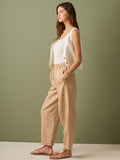 Pantalón de tiro medio con cintura elástica y cordón ajustable. Silueta relajada que cae con volumen en la cadera y se afina al tobillo, con bolsillos laterales y cortes decorativos en la pierna. Largo al tobillo con pequeña abertura en el bajo: la base moderna y versátil para elevar looks de día o de noche.

Detalles:

Color: Sand

Material: 77% Tencel 23% Lino 100% Rayón
