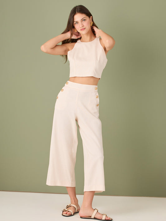 Pantalón culotte de tiro alto y pierna ancha; largo cropped que alarga la silueta, cintura entallada y botones laterales estilo marinero—versátil y elegante para looks casual-chic

Detalles:

Color: Ivory

Material: 100% lino. Forro 100% Rayón