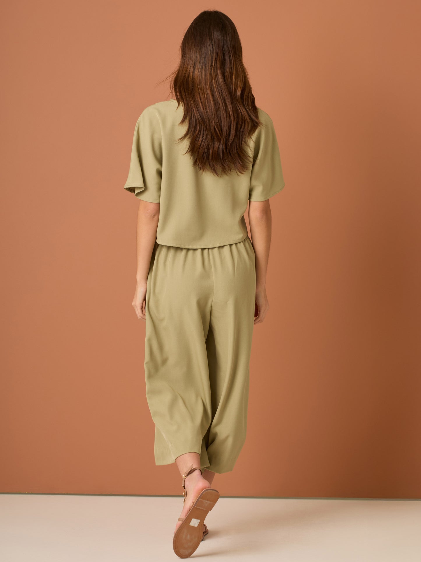 Con una silueta relajada y favorecedora, este pantalón amplio ofrece comodidad sin sacrificar estilo. Su pretina elástica asegura un ajuste cómodo y práctico, mientras que el largo al tobillo y la caída ligera lo convierten en una opción ideal para looks casuales sofisticados o días de movimiento con un aire minimalista y pulido.