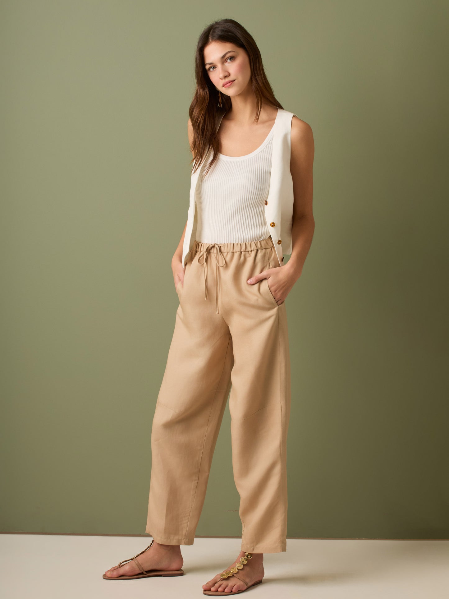 Pantalón de tiro medio con cintura elástica y cordón ajustable. Silueta relajada que cae con volumen en la cadera y se afina al tobillo, con bolsillos laterales y cortes decorativos en la pierna. Largo al tobillo con pequeña abertura en el bajo: la base moderna y versátil para elevar looks de día o de noche.

Detalles:

Color: Sand

Material: 77% Tencel 23% Lino 100% Rayón