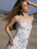 Esta blusa es tipo top strapless, ajustada al cuerpo, con escote recto y sin mangas, lo que deja los hombros y brazos completamente descubiertos. Está confeccionada en una tela ligera con estampado floral en tonos azul claro sobre fondo blanco, aportando un aire fresco y femenino. Su diseño corto deja ver ligeramente el abdomen, ideal para climas cálidos o looks playeros. Es una prenda versátil que combina estilo y comodidad.

Detalles:

Color: Blanco

Material: 100% Lyocel