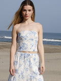 Esta blusa es tipo top strapless, ajustada al cuerpo, con escote recto y sin mangas, lo que deja los hombros y brazos completamente descubiertos. Está confeccionada en una tela ligera con estampado floral en tonos azul claro sobre fondo blanco, aportando un aire fresco y femenino. Su diseño corto deja ver ligeramente el abdomen, ideal para climas cálidos o looks playeros. Es una prenda versátil que combina estilo y comodidad.

Detalles:

Color: Blanco

Material: 100% Lyocel