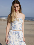 Esta blusa es tipo top strapless, ajustada al cuerpo, con escote recto y sin mangas, lo que deja los hombros y brazos completamente descubiertos. Está confeccionada en una tela ligera con estampado floral en tonos azul claro sobre fondo blanco, aportando un aire fresco y femenino. Su diseño corto deja ver ligeramente el abdomen, ideal para climas cálidos o looks playeros. Es una prenda versátil que combina estilo y comodidad.

Detalles:

Color: Blanco

Material: 100% Lyocel