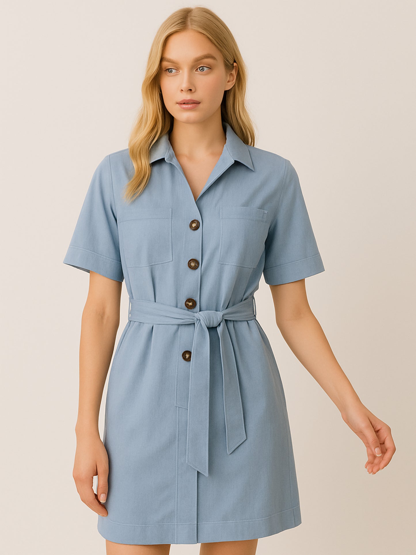 Este vestido camisero de silueta recta combina la estructura de una prenda utilitaria con la frescura de un look contemporáneo. Con cuello tipo solapa, botones frontales contrastantes y bolsillos superiores de parche, incorpora un cinturón del mismo tejido que define la cintura y aporta feminidad. El largo sobre la rodilla lo convierte en una opción versátil para días cálidos, perfecta para el trabajo, una salida casual o un look urbano pulido.