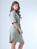 Este vestido camisero de silueta recta combina la estructura de una prenda utilitaria con la frescura de un look contemporáneo. Con cuello tipo solapa, botones frontales contrastantes y bolsillos superiores de parche, incorpora un cinturón del mismo tejido que define la cintura y aporta feminidad. El largo sobre la rodilla lo convierte en una opción versátil para días cálidos, perfecta para el trabajo, una salida casual o un look urbano pulido.