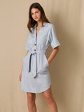 Este vestido camisero de silueta recta combina la estructura de una prenda utilitaria con la frescura de un look contemporáneo. Con cuello tipo solapa, botones frontales contrastantes y bolsillos superiores de parche, incorpora un cinturón del mismo tejido que define la cintura y aporta feminidad. El largo sobre la rodilla lo convierte en una opción versátil para días cálidos, perfecta para el trabajo, una salida casual o un look urbano pulido.