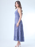 Vestido largo con escote en V profundo y tirantes finos. El cuerpo tiene un diseño cruzado que acentúa el busto y estiliza la figura. La falda está compuesta por paneles amplios con sutiles volantes, que aportan fluidez y un aire romántico. Ideal para un look femenino y relajado.