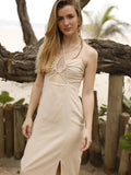 Vestido largo de tirantes delgados con escote halter. Tiene un detalle fruncido en el busto con abertura frontal y un pequeño corte debajo del pecho. La falda incluye una abertura frontal que aporta movimiento y frescura al diseño. Silueta ajustada al cuerpo con caída fluida. Ideal para un look de playa o verano.