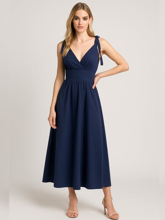 Este vestido presenta un diseño elegante y femenino. Tiene un escote en "V" cruzado que estiliza el busto y una cintura ancha tipo fajón que define la silueta. Los tirantes se anudan sobre los hombros, agregando un toque delicado y ajustable al diseño. La falda cae en corte evasé hasta los tobillos, con una caída fluida que favorece el movimiento. Su estilo atemporal lo hace ideal tanto para eventos de día como para cenas o celebraciones formales. Puede combinarse con tacones o sandalias.

Detalles:

Color: