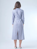 Vestido camisero midi con diseño de rayas verticales. Tiene cuello clásico, mangas largas con puños y un corte cruzado al frente que se ajusta con un lazo a la cintura. La falda cae con movimiento sutil y el ajuste en la cintura define la silueta de forma favorecedora. Es una prenda cómoda, estructurada y con un aire sofisticado.

Detalles:

Color: Azul