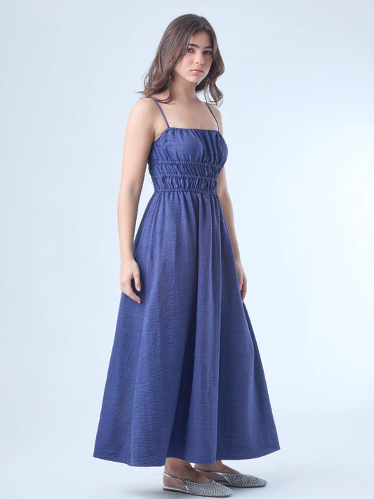 Vestido largo de tirantes delgados con escote recto. Tiene un diseño fruncido en la parte superior y en la cintura, que aporta textura y define la silueta. La falda cae de forma fluida y suelta, dando una sensación de ligereza y movimiento. Es una prenda cómoda y versátil, ideal para un estilo relajado pero elegante.

Detalles:

Color: Navy